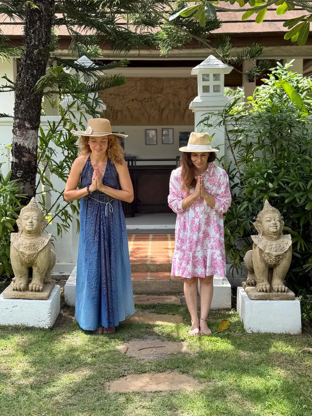 Duas mulheres em saudação, em um jardim na Tailândia